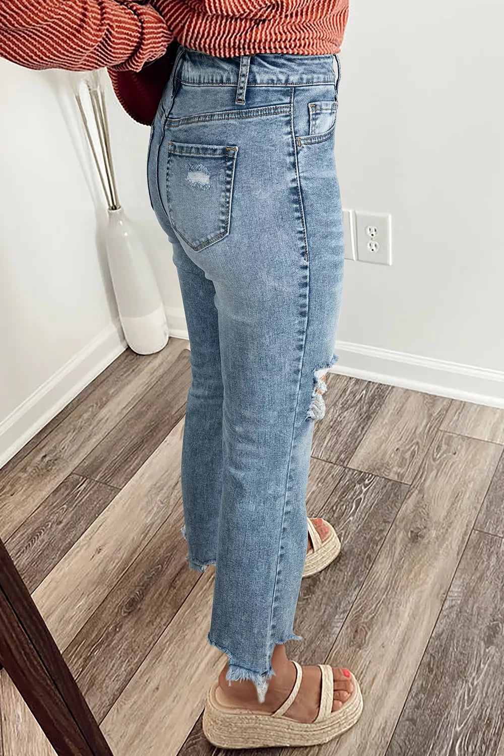 Woman wearing ripped open knee flare jeans