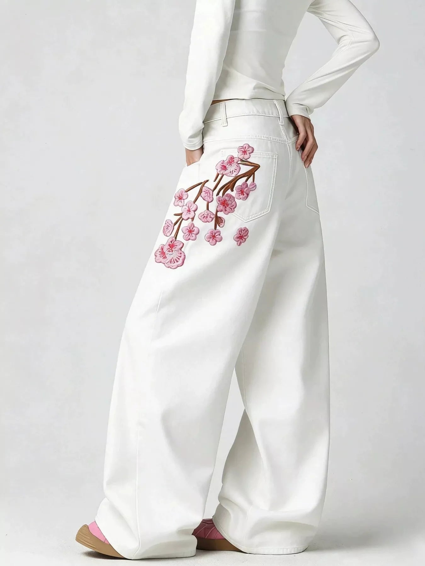 Embroidery detail on white wide leg jeans