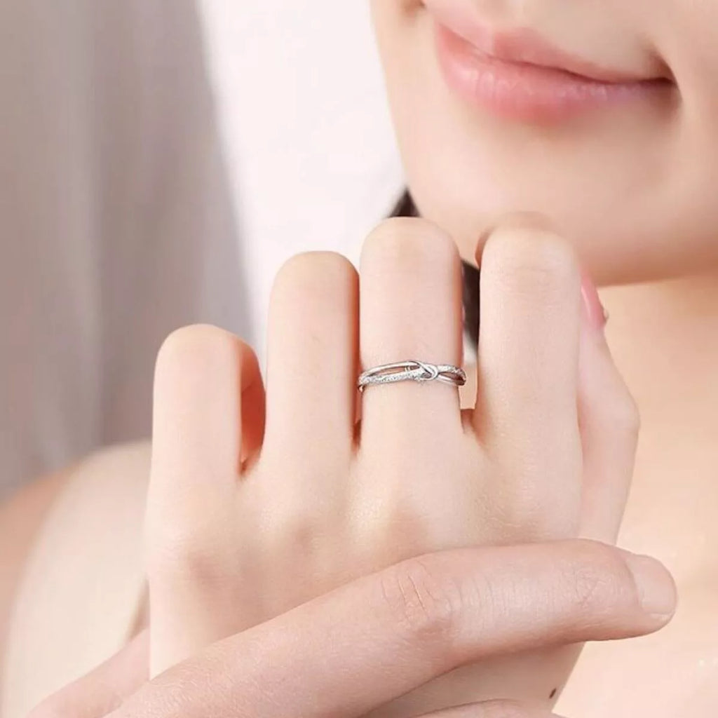Silver knot ring shown on finger