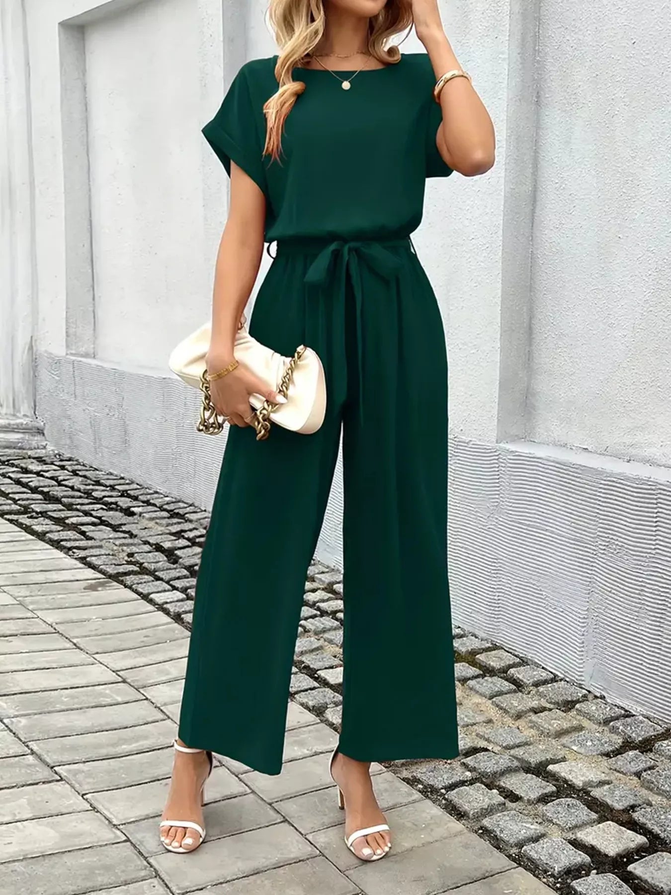 Model posing in tie waist wide leg jumpsuit
