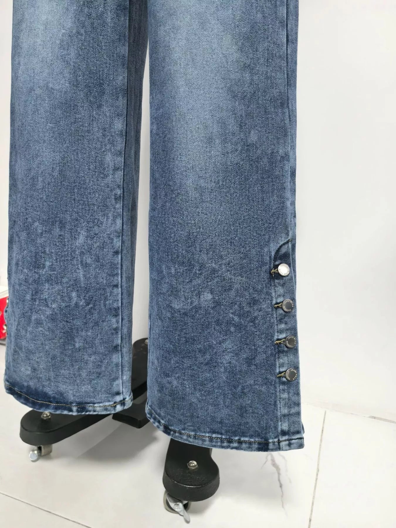 Blue denim fabric and stitching detail on wide leg jeans