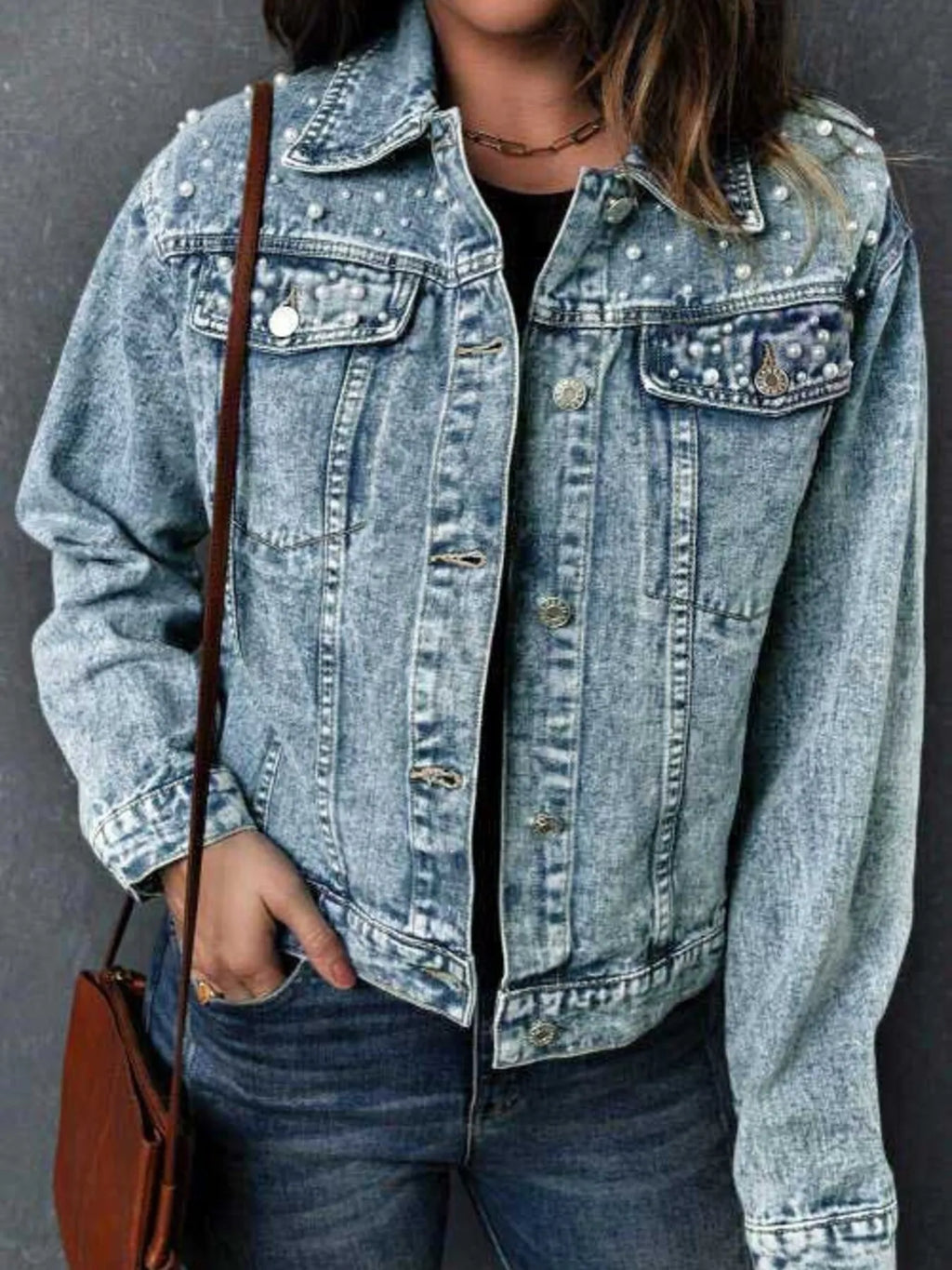 Close up of pearl button detail on denim jacket