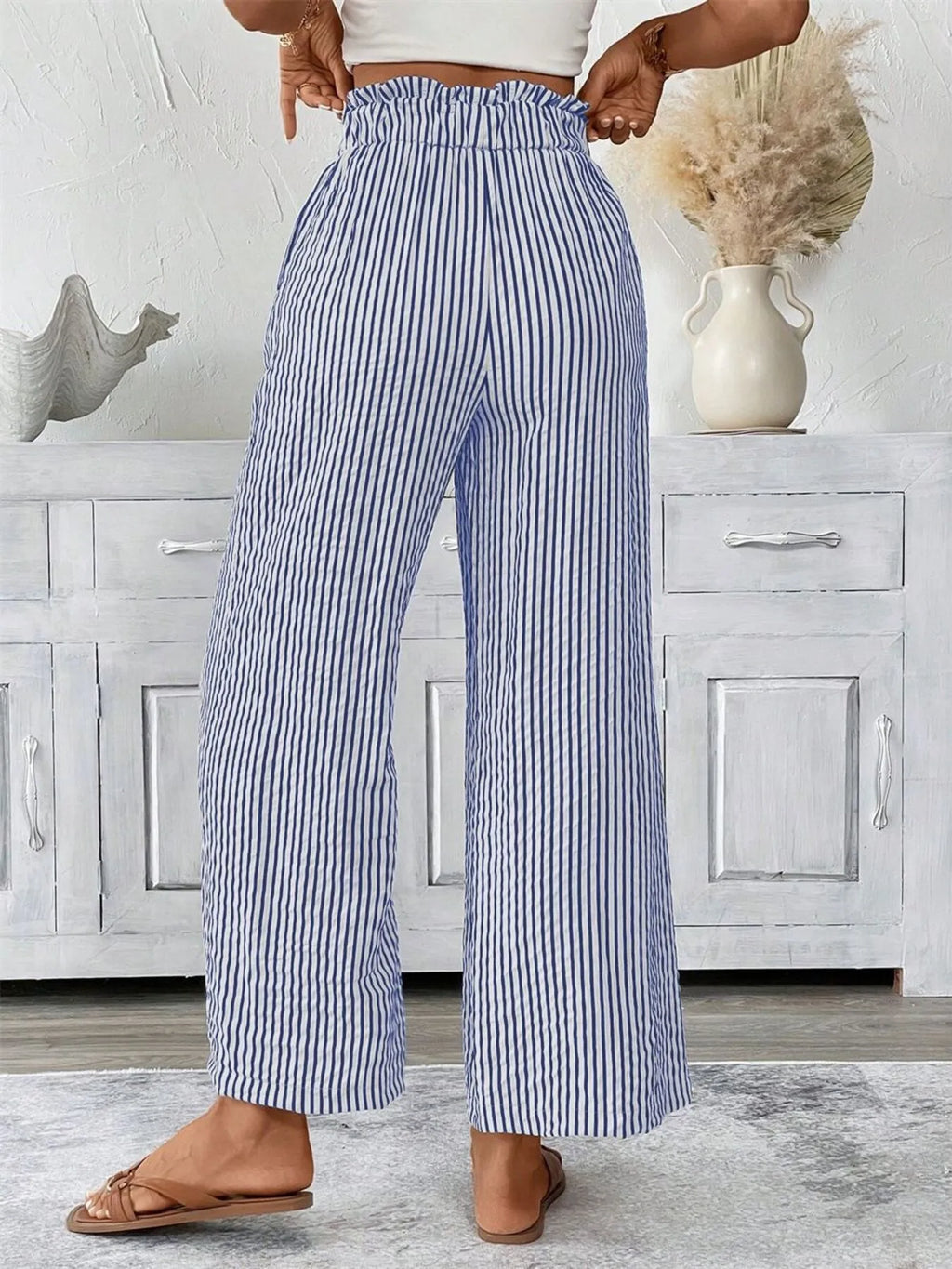Woman wearing blue wide leg paper bag pants front view