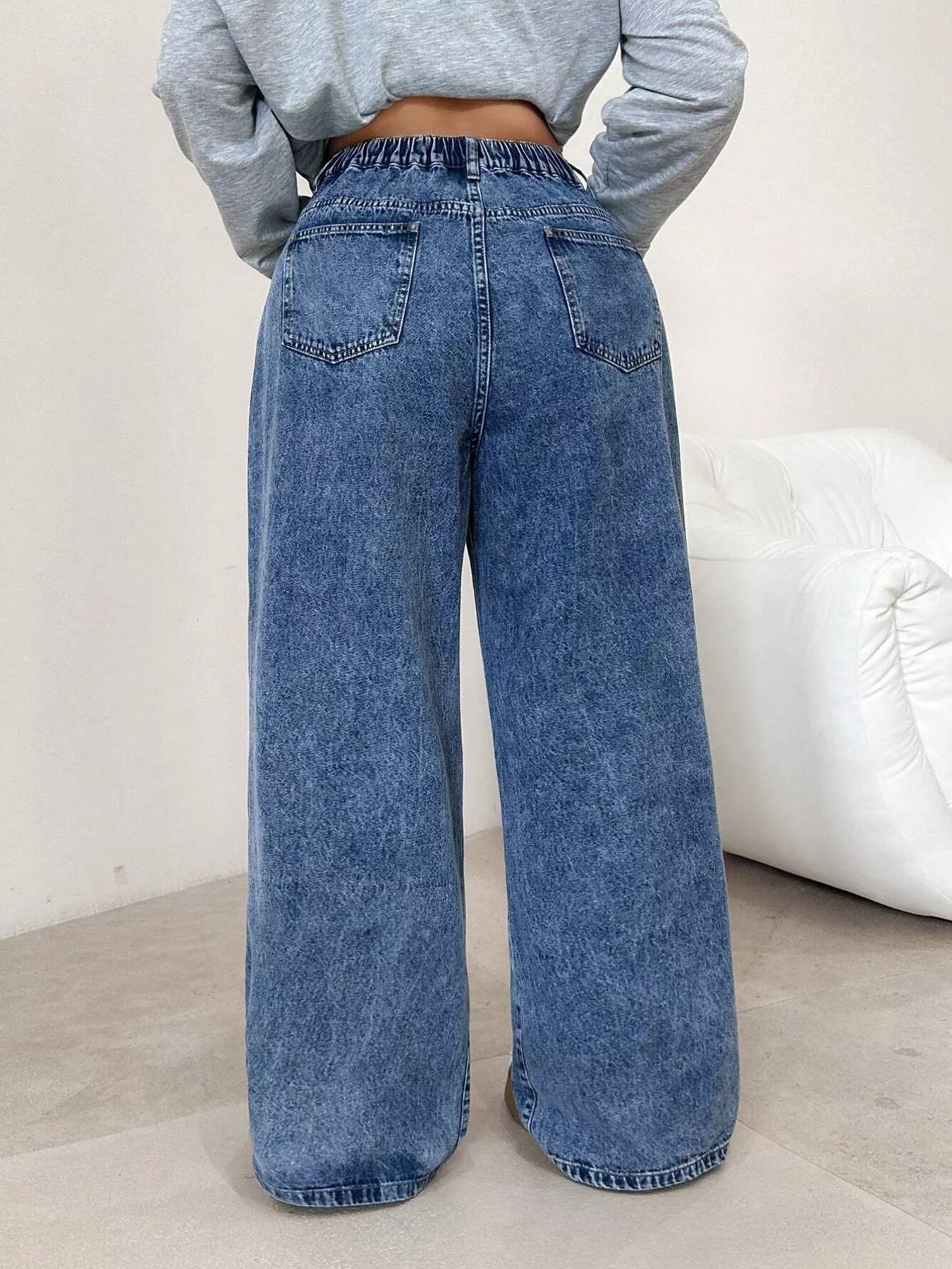 Side view of dark blue cross embellished wide leg jeans