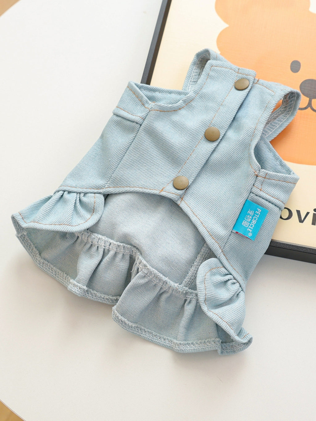 Small dog wearing denim ruffle dress styled