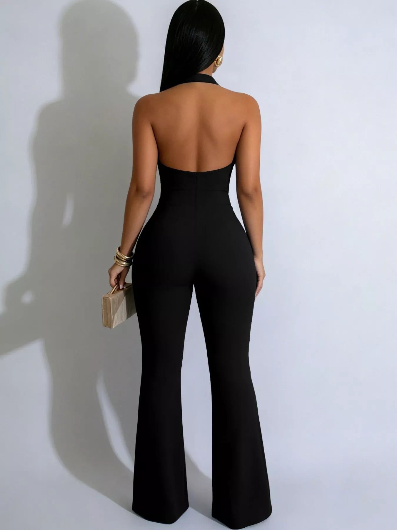 Black halter neck cut out jumpsuit styled with heels