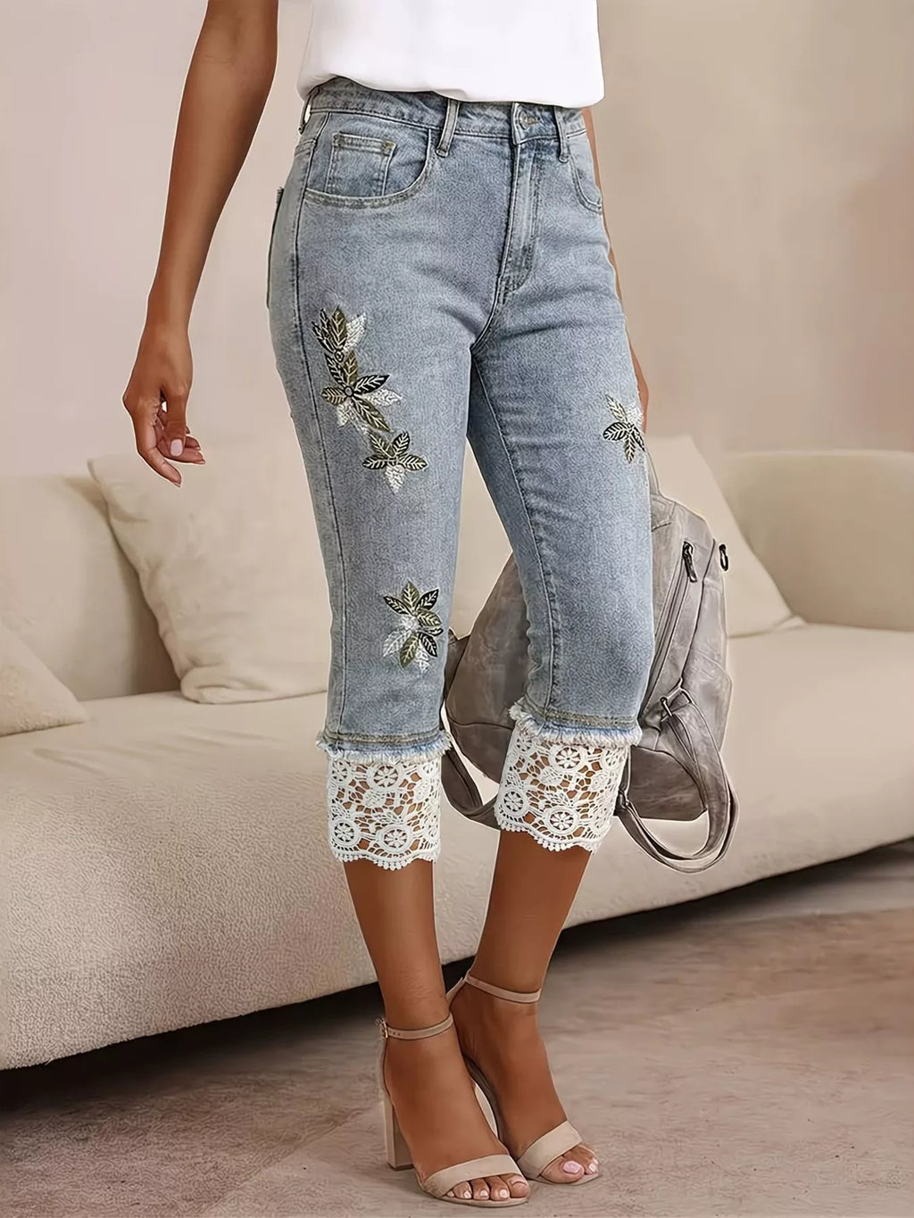 Lace trim and embroidery detail on blue capri denim