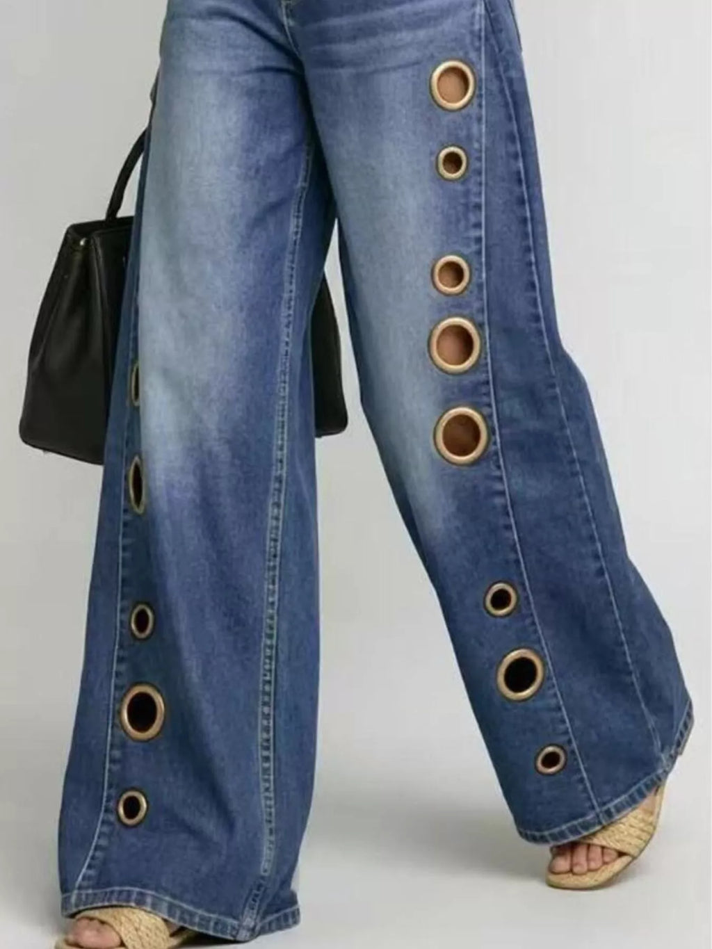 Metal eyelet embellishment detail on denim