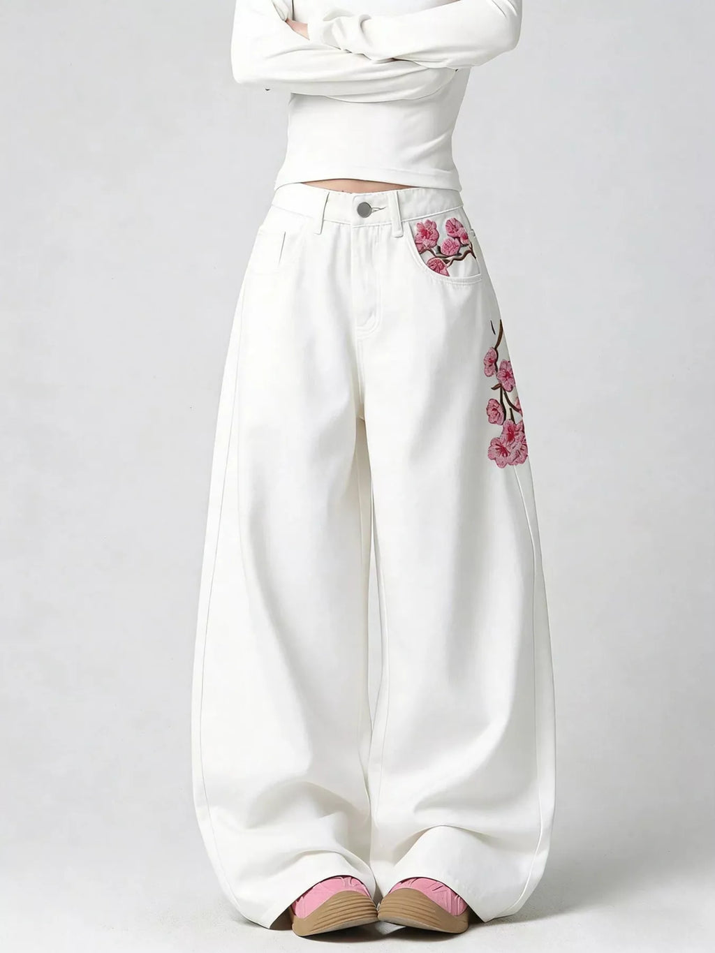 Woman wearing embroidered wide leg jeans in white