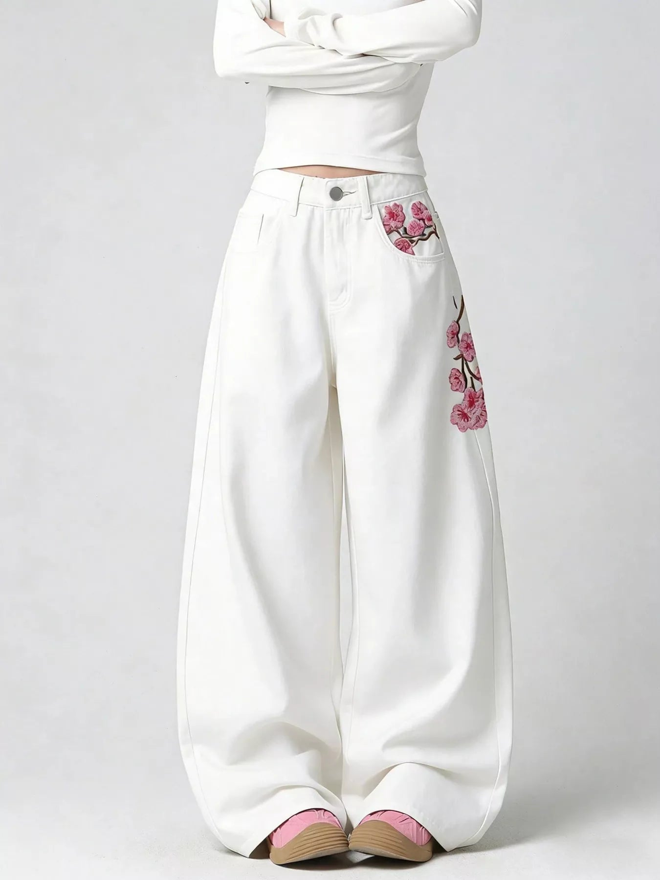 Woman wearing embroidered wide leg jeans in white