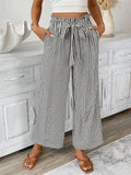 Woman wearing black wide leg paper bag pants front view