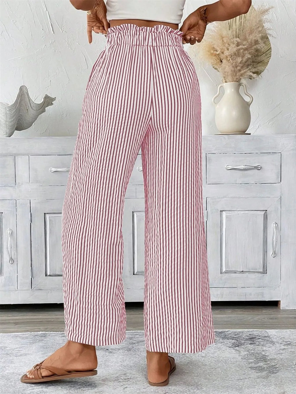 Woman wearing dusty pink wide leg paper bag pants front view