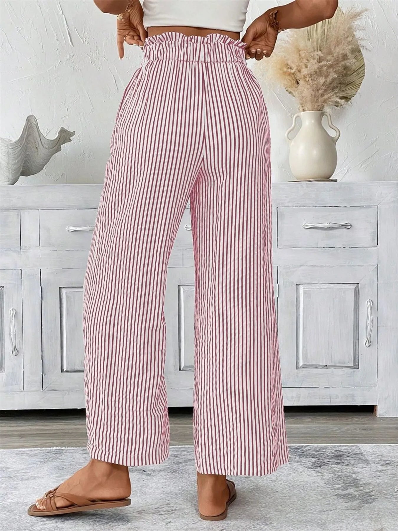 Woman wearing dusty pink wide leg paper bag pants front view