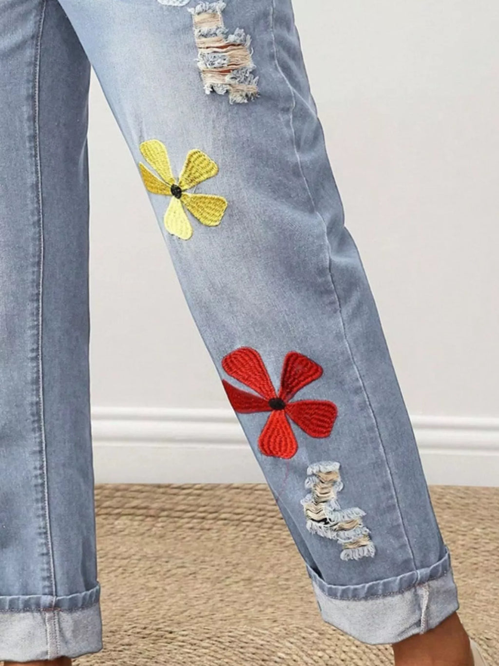 Woman wearing flower embroidered distressed jeans