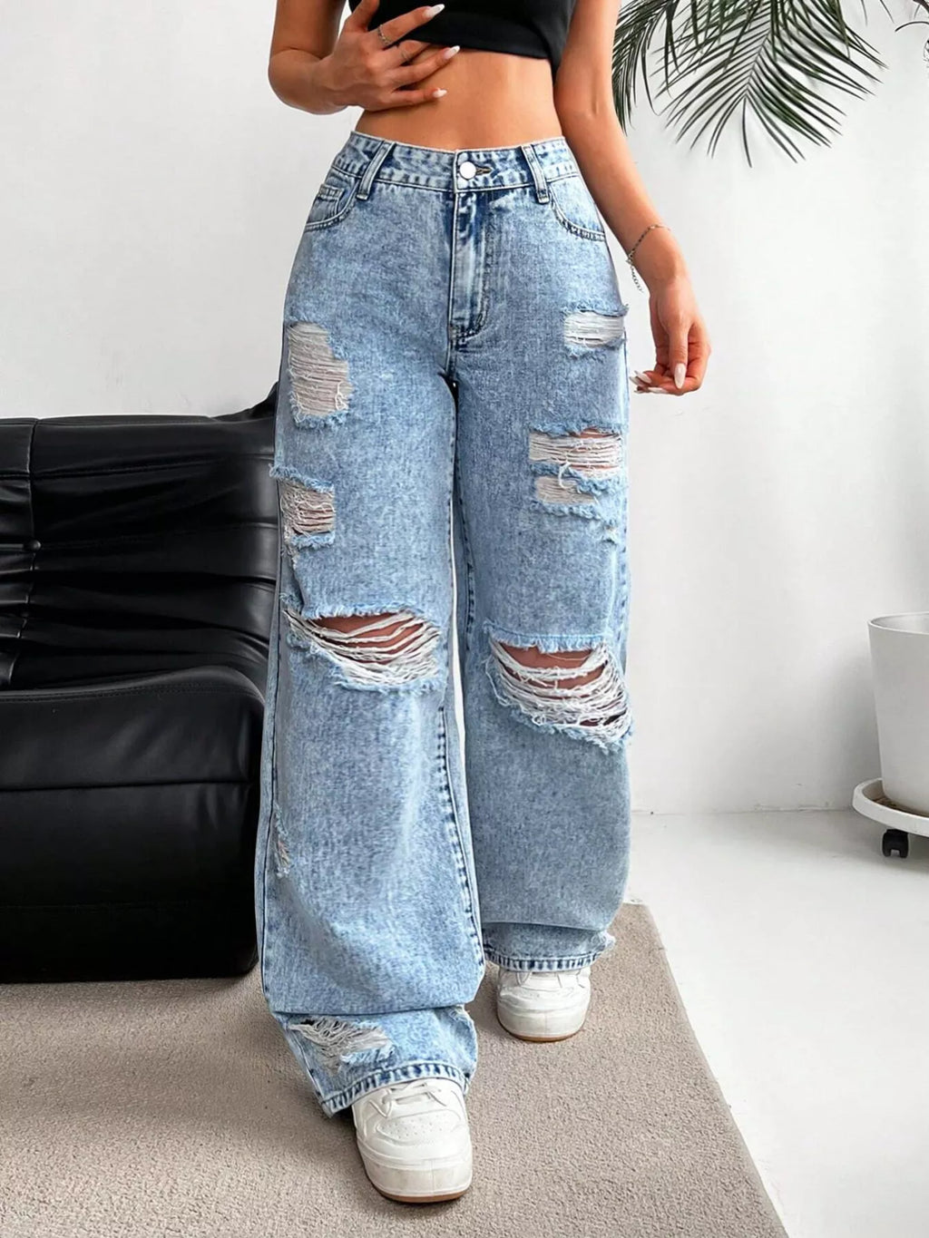 Woman wearing distressed wide leg jeans