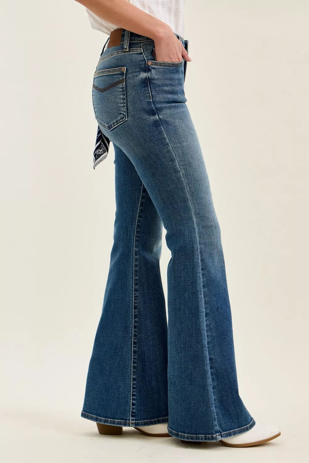 Woman wearing mid rise flare jeans in medium wash