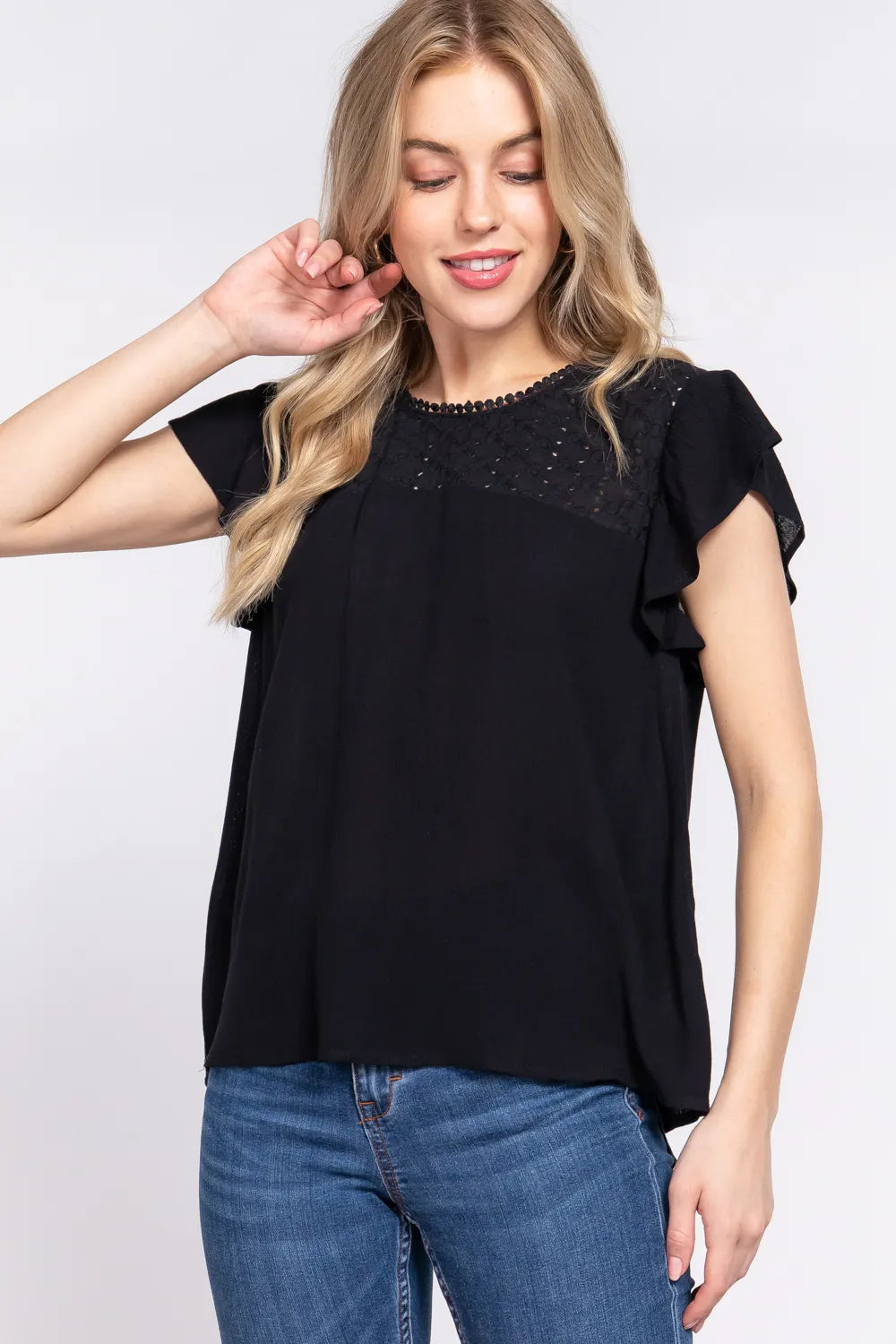 Ruffle short sleeve crochet blouse in black front view on model