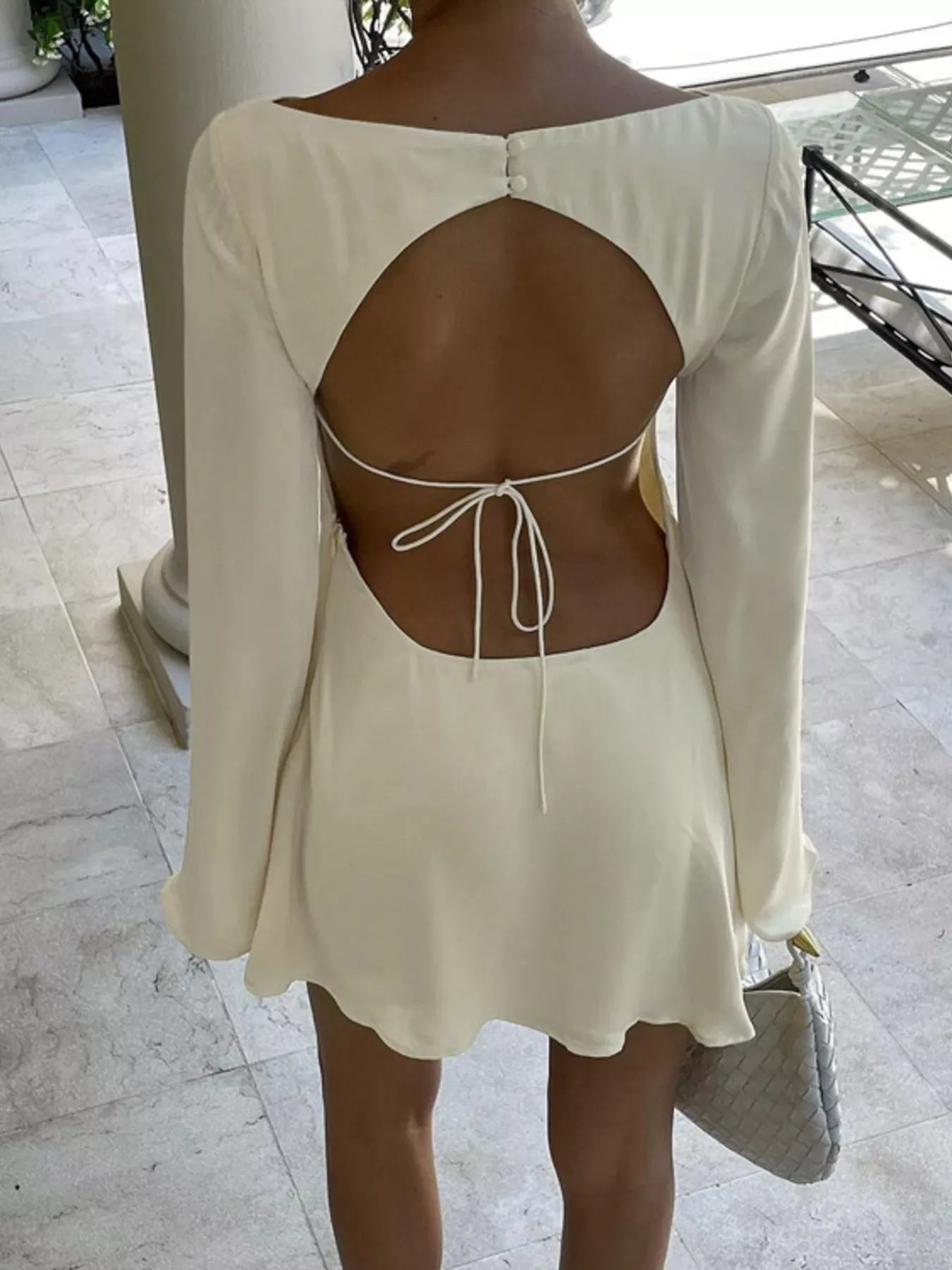 Backless mini dress shown on model