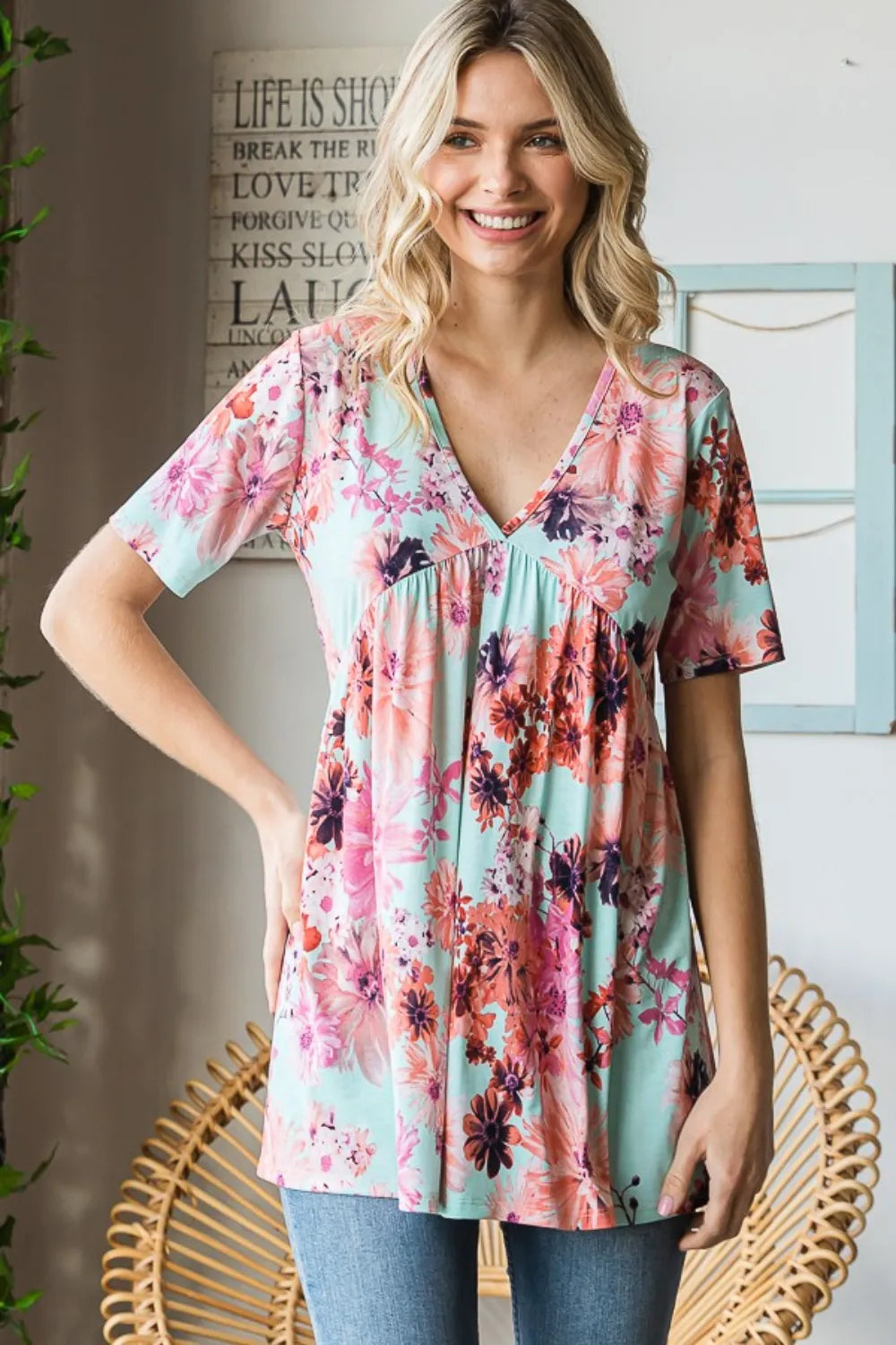 Woman wearing mint floral V neck babydoll blouse front view