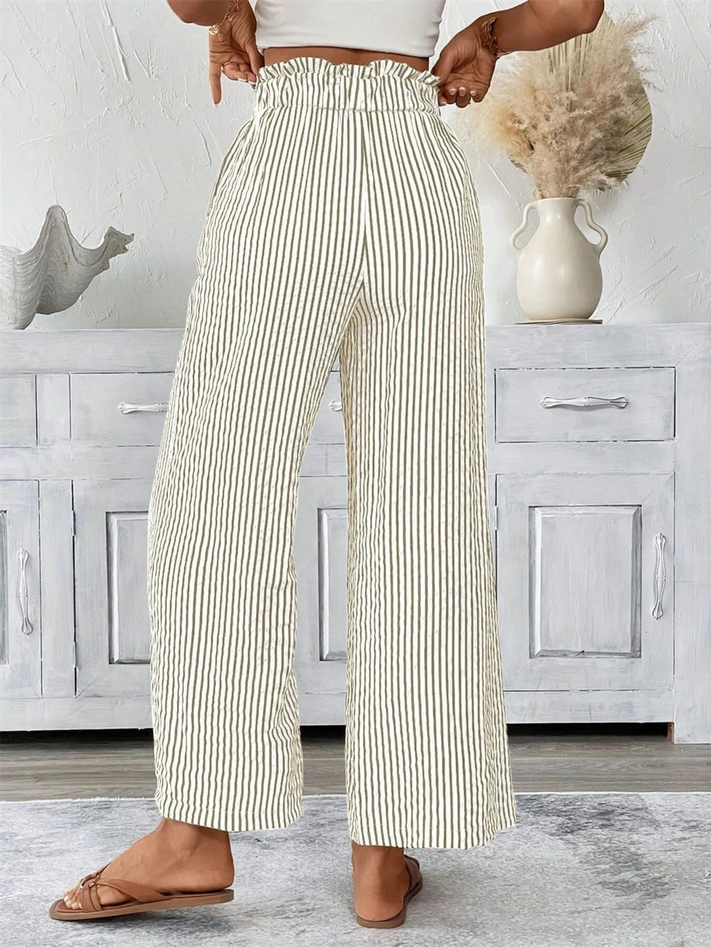 Woman wearing khaki wide leg paper bag pants front view