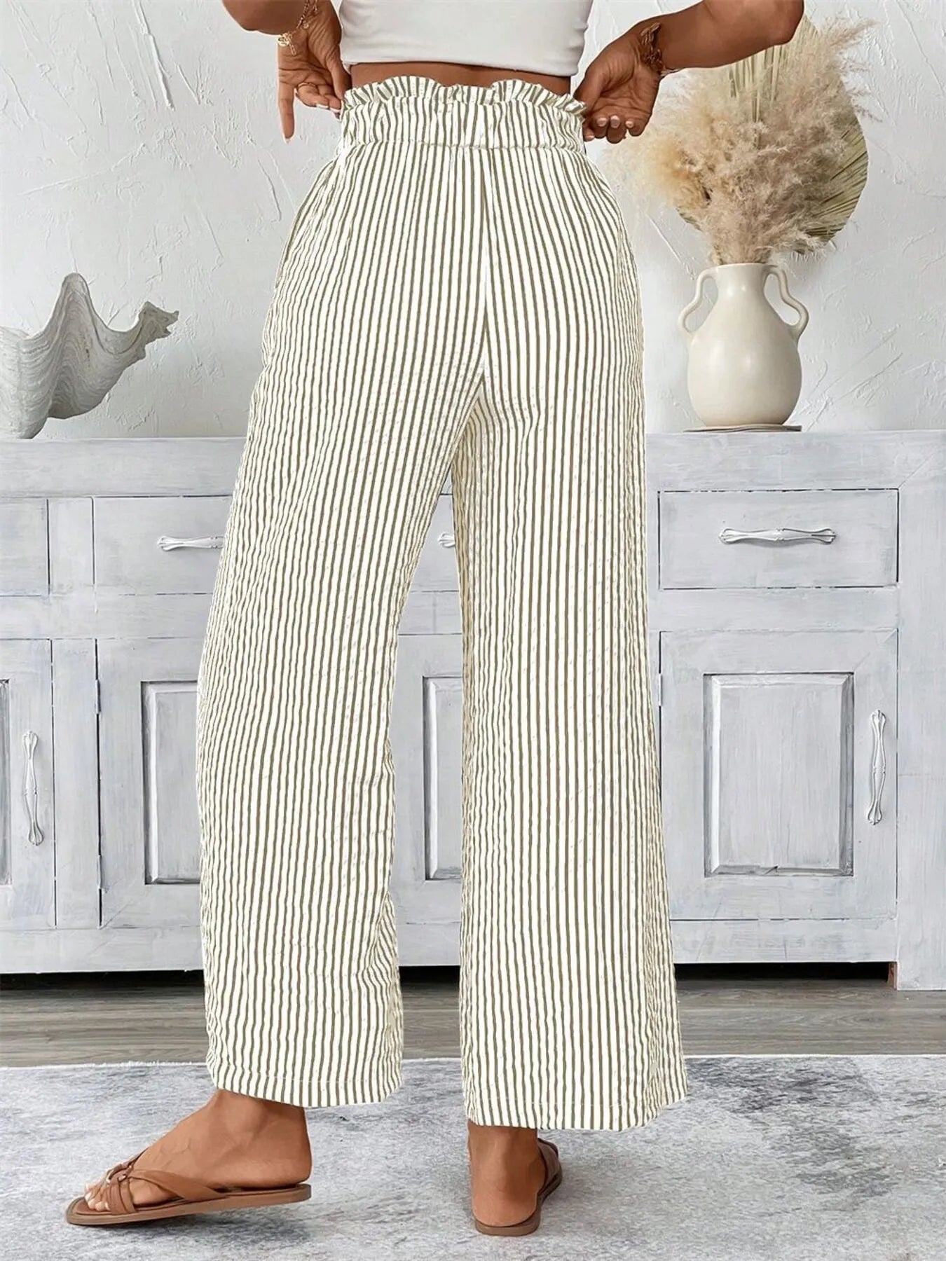 Woman wearing khaki wide leg paper bag pants front view