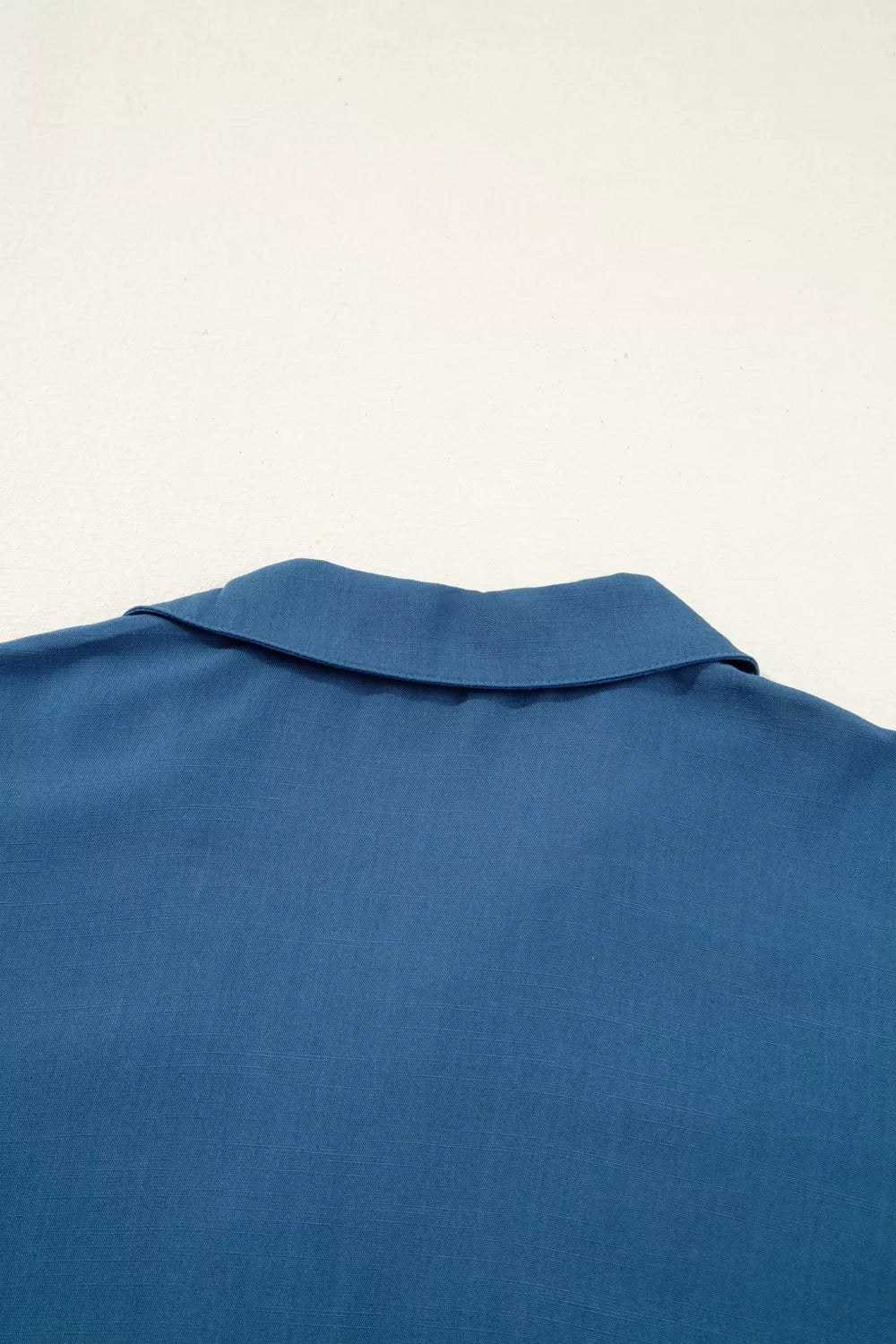 Button detail blouse shown on hanger