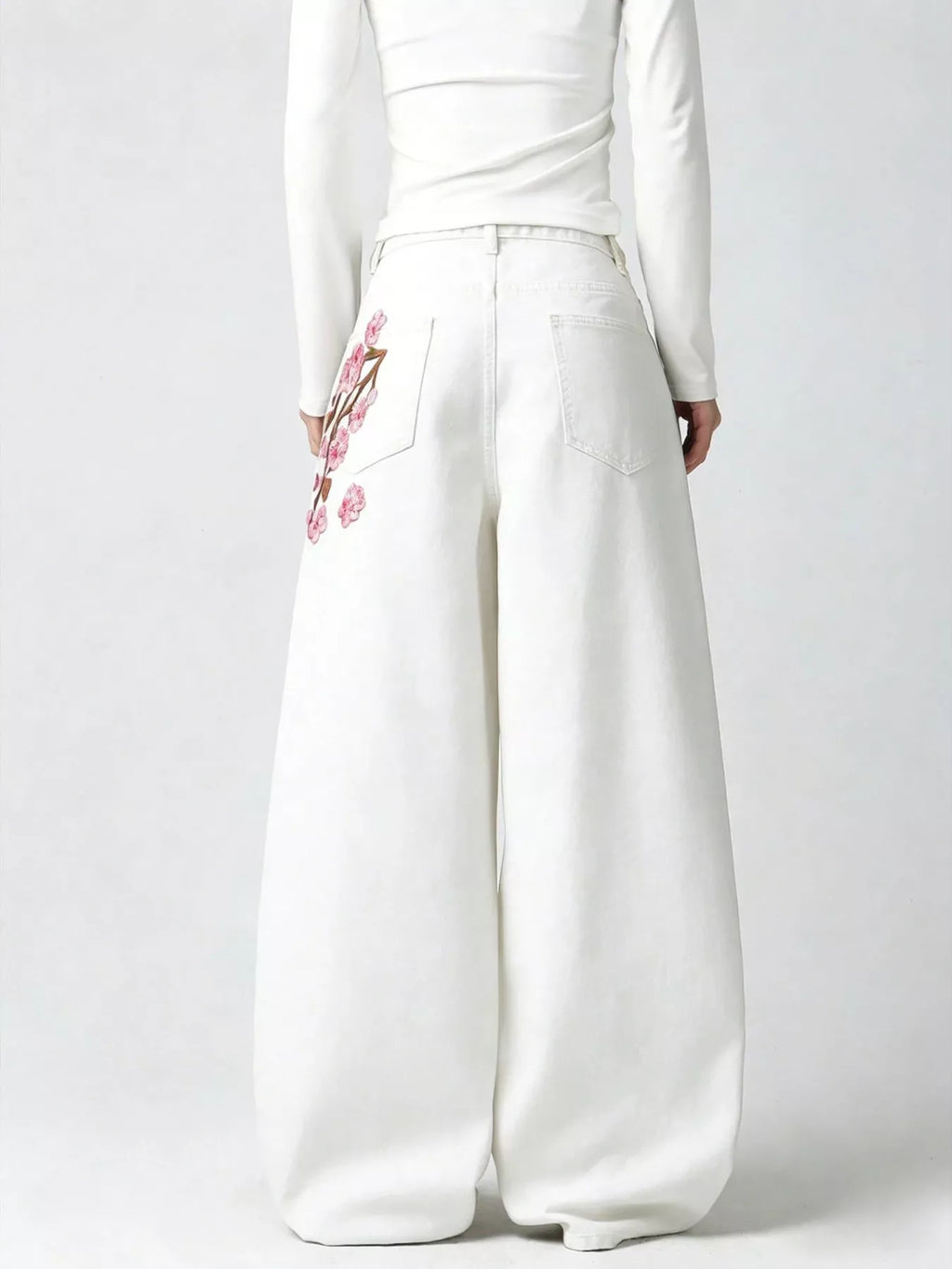 Woman wearing embroidered wide leg jeans in black