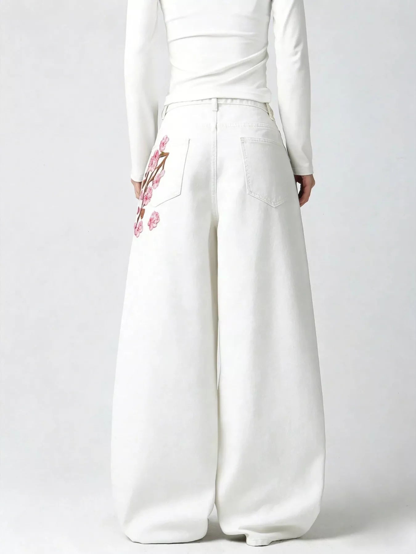 Woman wearing embroidered wide leg jeans in black