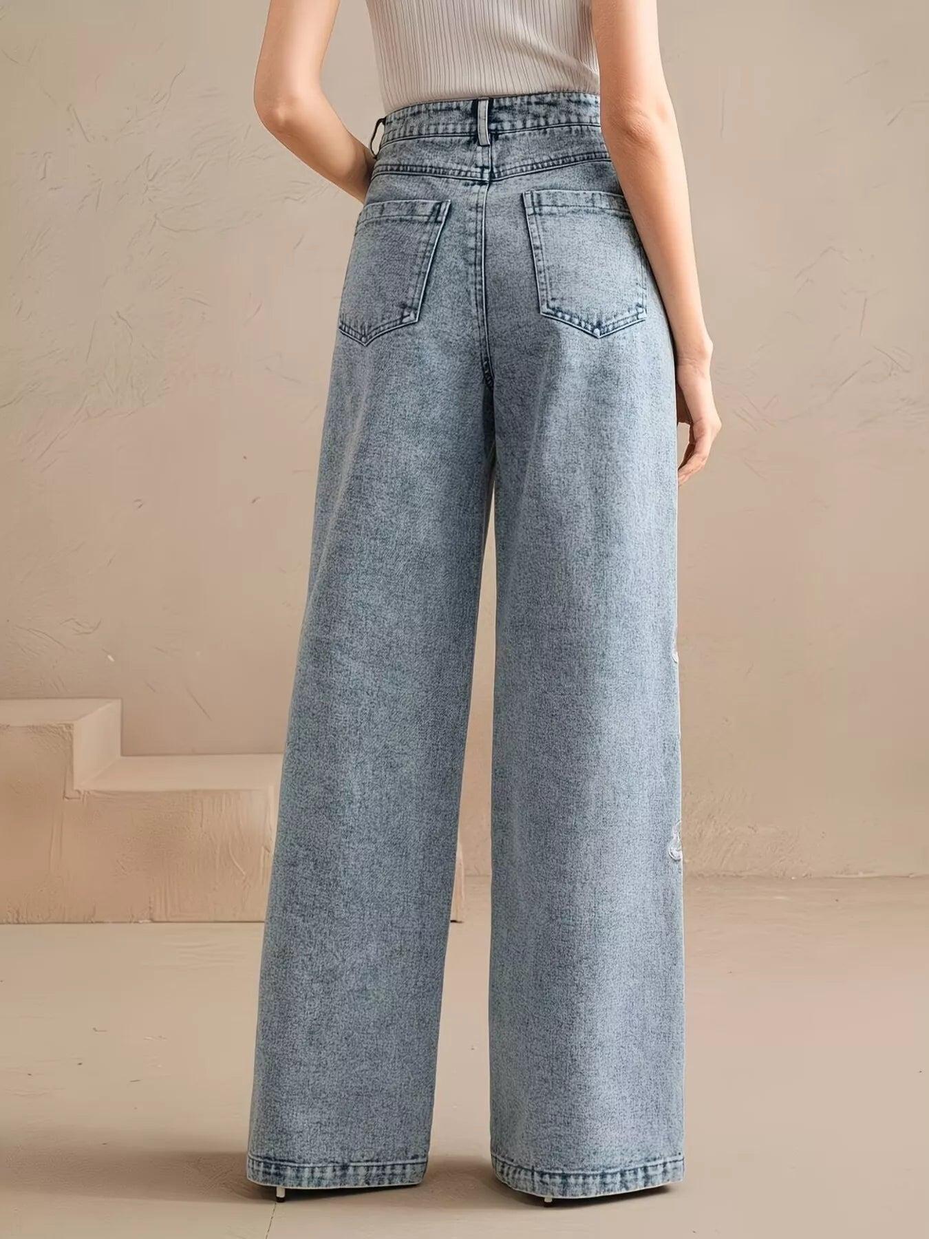 Woman wearing embroidered wide leg jeans in blue