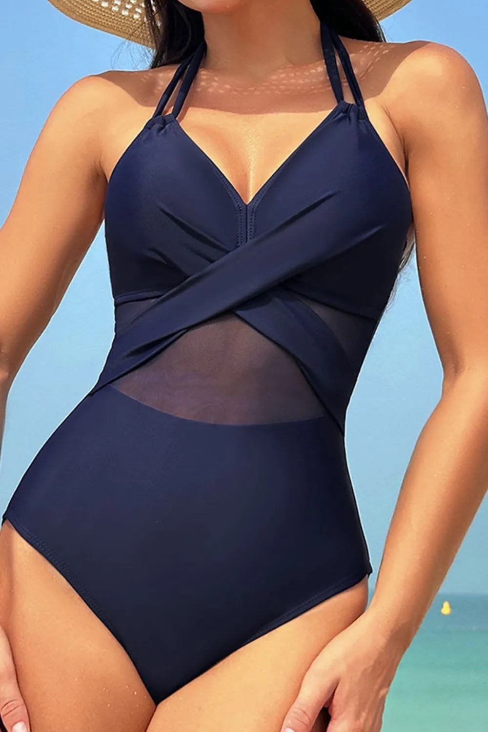 Model wearing black crisscross halter swimsuit