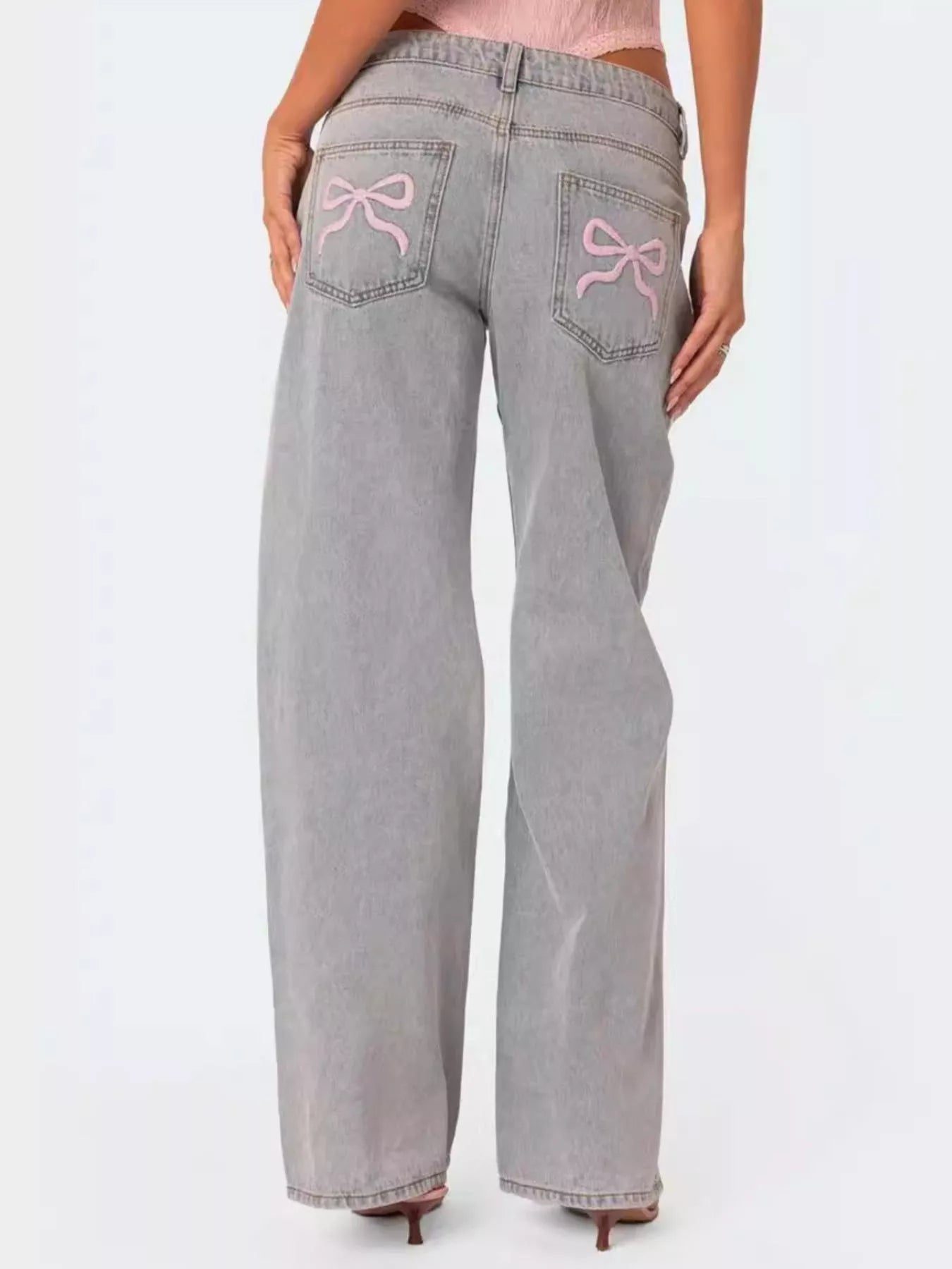 Button closure and waistband detail on light wash jeans