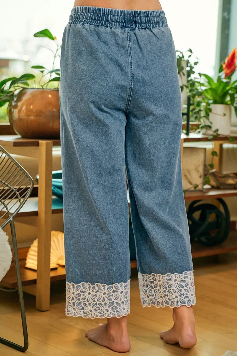 Woman wearing washed denim pants with lace trim waist