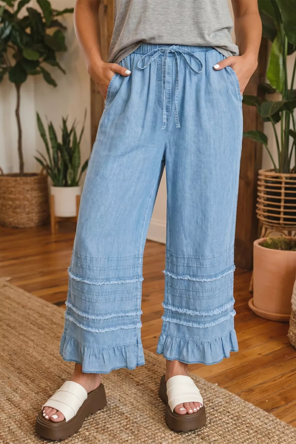 Light blue ruffle hem wide leg chambray jeans front view on model