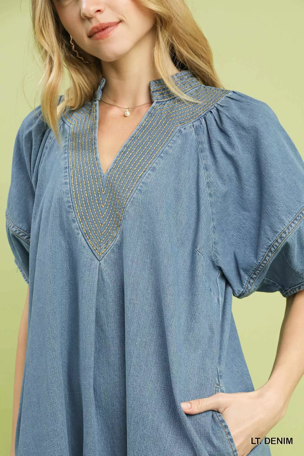 Contrast thread stitching and pocket detail on denim dress