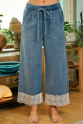 Washed denim pants with floral lace waist trim front view