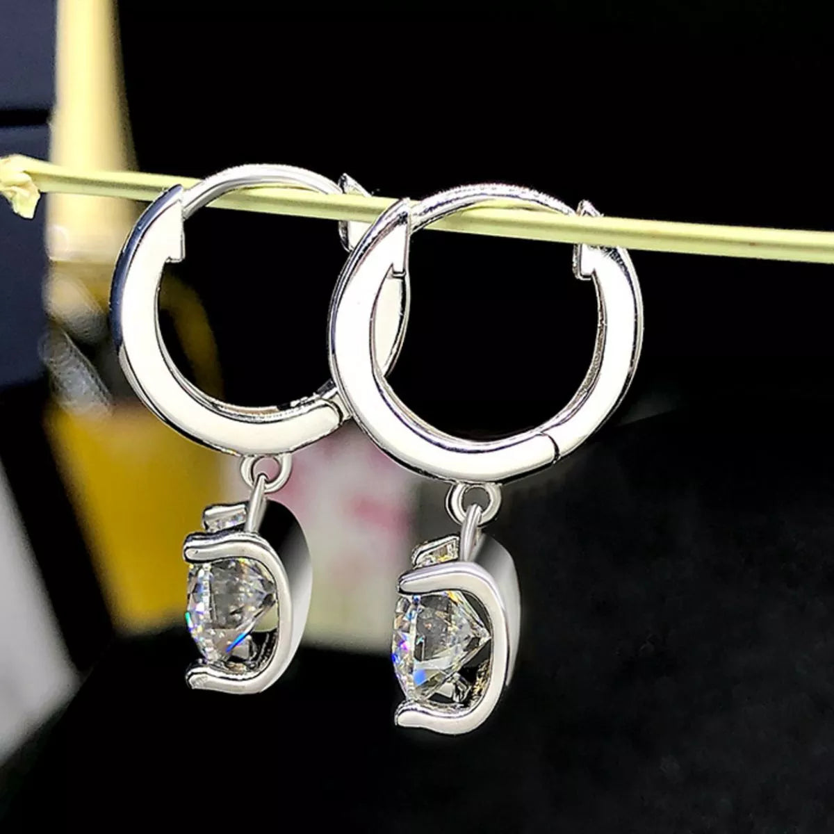 Moissanite drop earrings styled on model ear